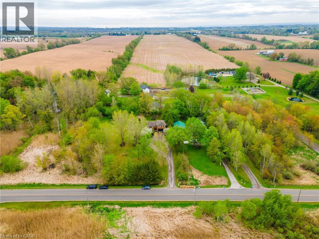 Expansive property featuring multiple driveways, mature trees, open green spaces, and a visible pond - 152 Concession 7 Road E, Millgrove, ON - Outdoor With View