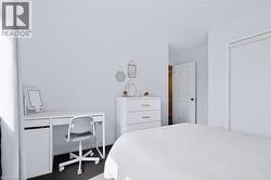 Built-in closet, white interior door, white dresser with drawers, white desk with storage, dark carpet flooring - 