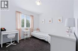 White walls with dark carpet flooring, a window featuring horizontal blinds and curtains, and a flush-mount ceiling light fixture - 