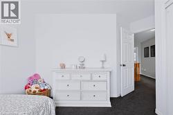 White paneled door with dark hardware, dark carpet flooring, and white painted walls - 
