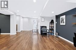 Spacious room with wood-finish flooring, recessed lighting, and a neutral color palette with accent walls - 