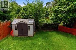 Expansive green lawn with a storage shed featuring dual skylights - 
