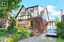 Tudor Revival architectural style featuring brick and half-timbering, a front entry archway, decorative window awnings, and an interlocking brick driveway - 107 Bond Street S, Hamilton, ON  - Outdoor 