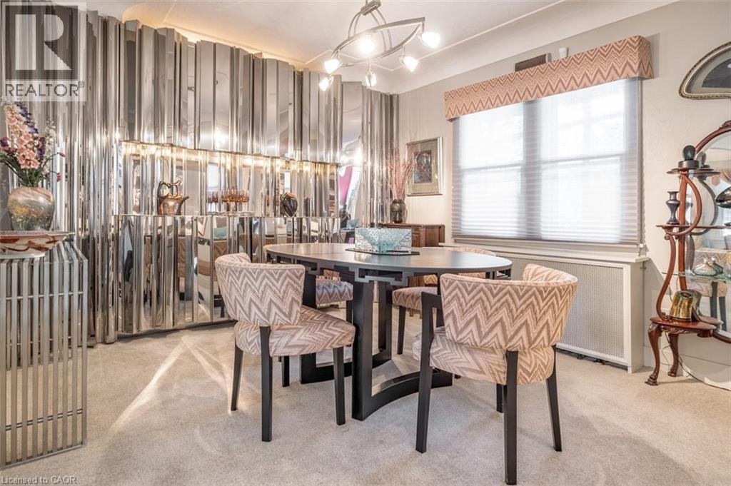 Textured wall paneling, window with blinds, overhead light fixture, carpeted flooring, and a built-in display cabinet - 107 Bond Street S, Hamilton, ON - Indoor Photo Showing Dining Room
