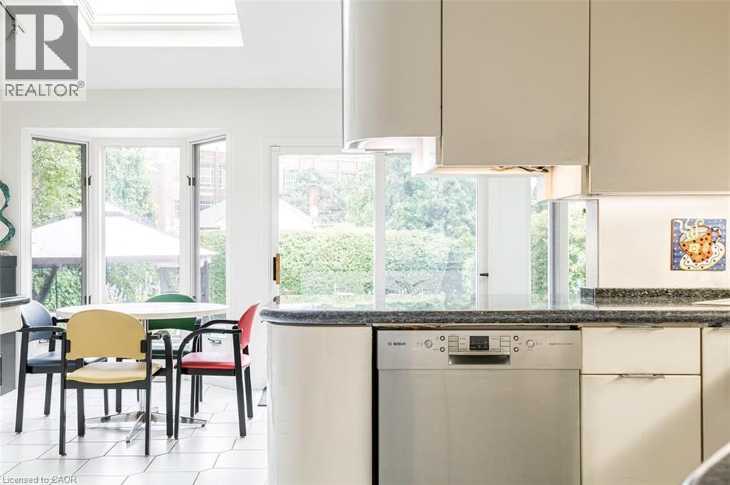 Kitchen featuring a skylight, bay window, light-toned cabinetry, and a built-in stainless steel dishwasher - 107 Bond Street S, Hamilton, ON - Indoor Photo Showing Kitchen