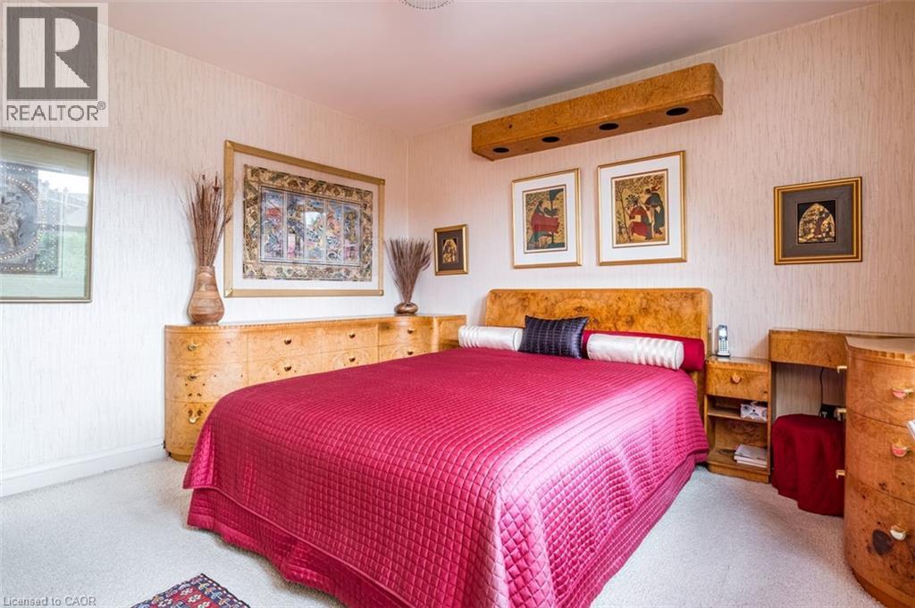 Textured wall covering, built-in headboard, wood-finish cabinetry, built-in lighting fixture, and carpeted flooring - 107 Bond Street S, Hamilton, ON - Indoor Photo Showing Bedroom