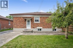 Brick exterior with a side entrance, concrete patio, and a mature fruit-bearing tree - 