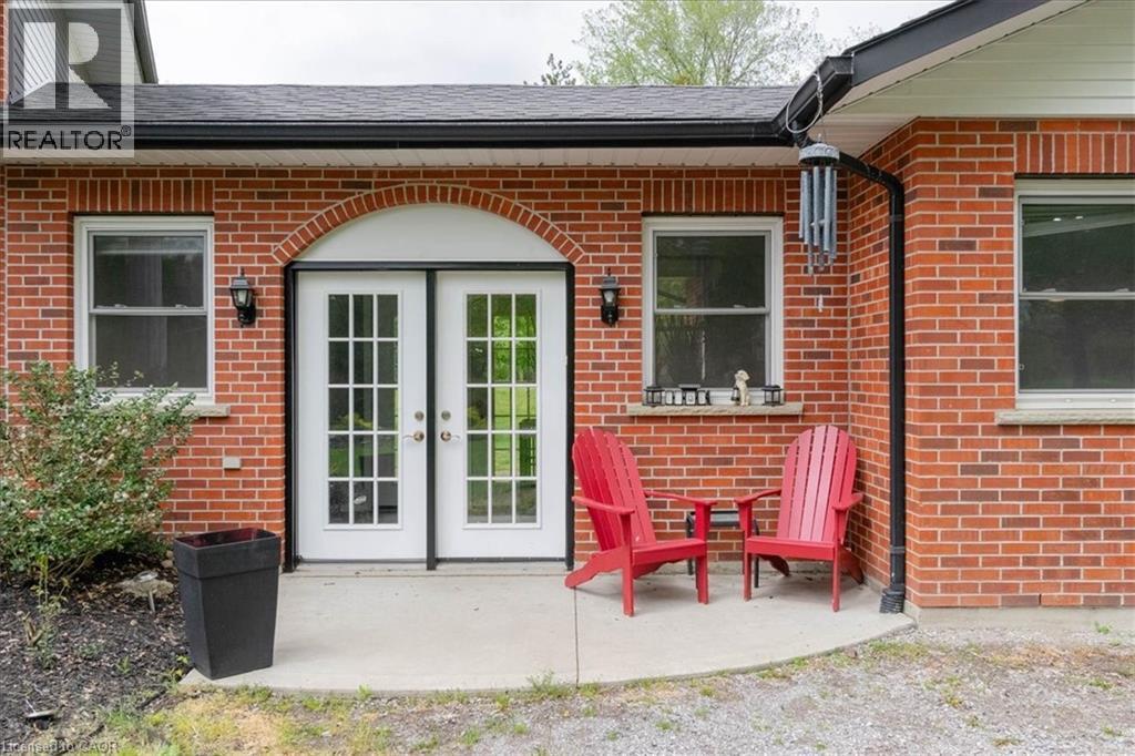 Brick exterior with a curved concrete patio - 111 Decou Road, Simcoe, ON - Outdoor With Exterior