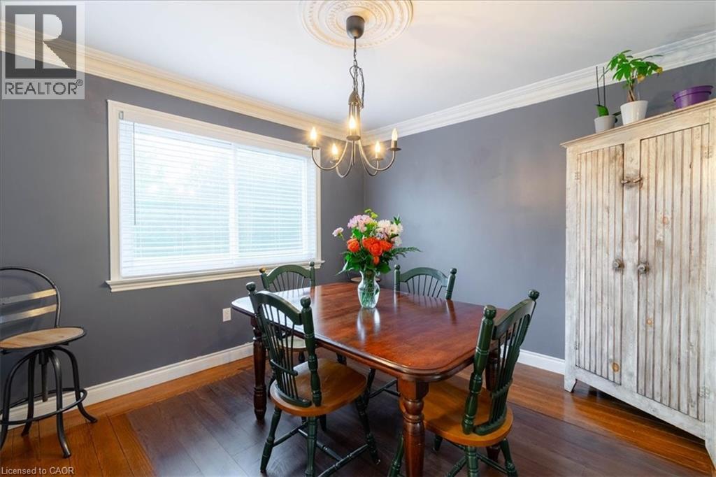 Dining area featuring wood-finish flooring, a large window and crown molding - 111 Decou Road, Simcoe, ON - Indoor Photo Showing Dining Room