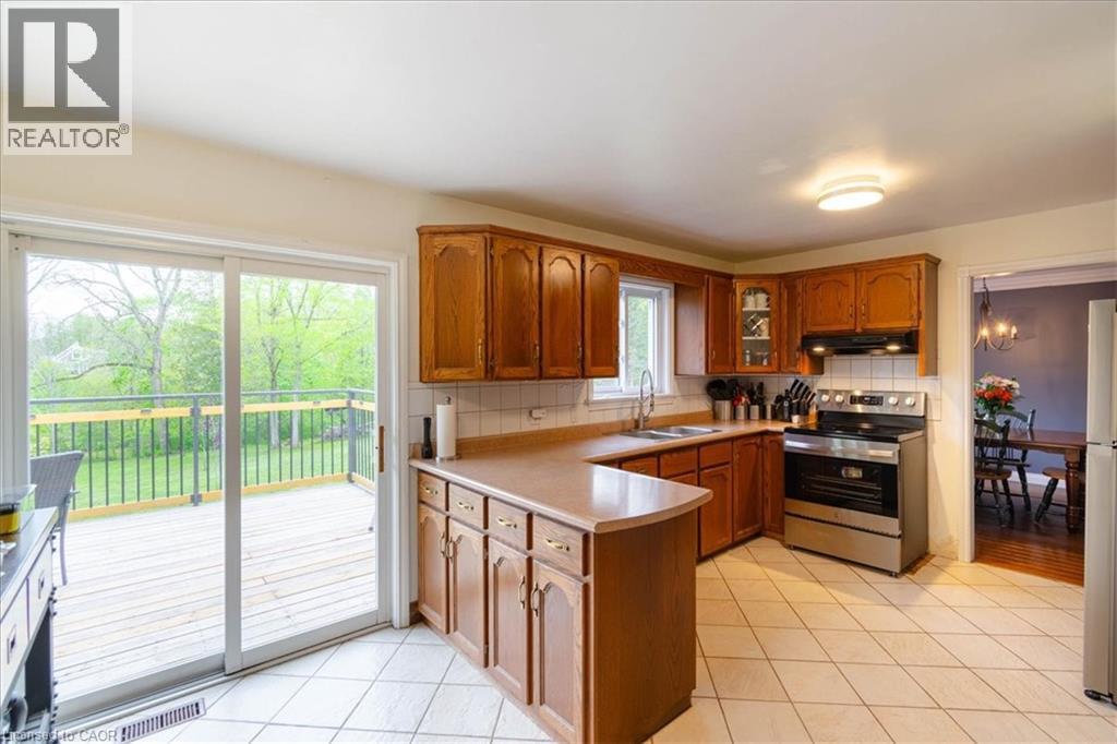 Kitchen featuring wood cabinetry, stainless steel range, and tile flooring - 111 Decou Road, Simcoe, ON - Indoor Photo Showing Kitchen With Double Sink