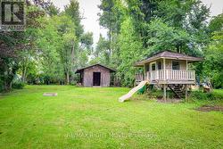 Deep backyard with storage building & playhouse. - 