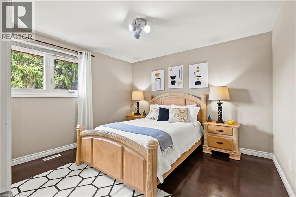 Dark wood-finish flooring, light neutral wall color, and white trim - 87 Monte Drive, Hamilton, ON - Indoor Photo Showing Bedroom