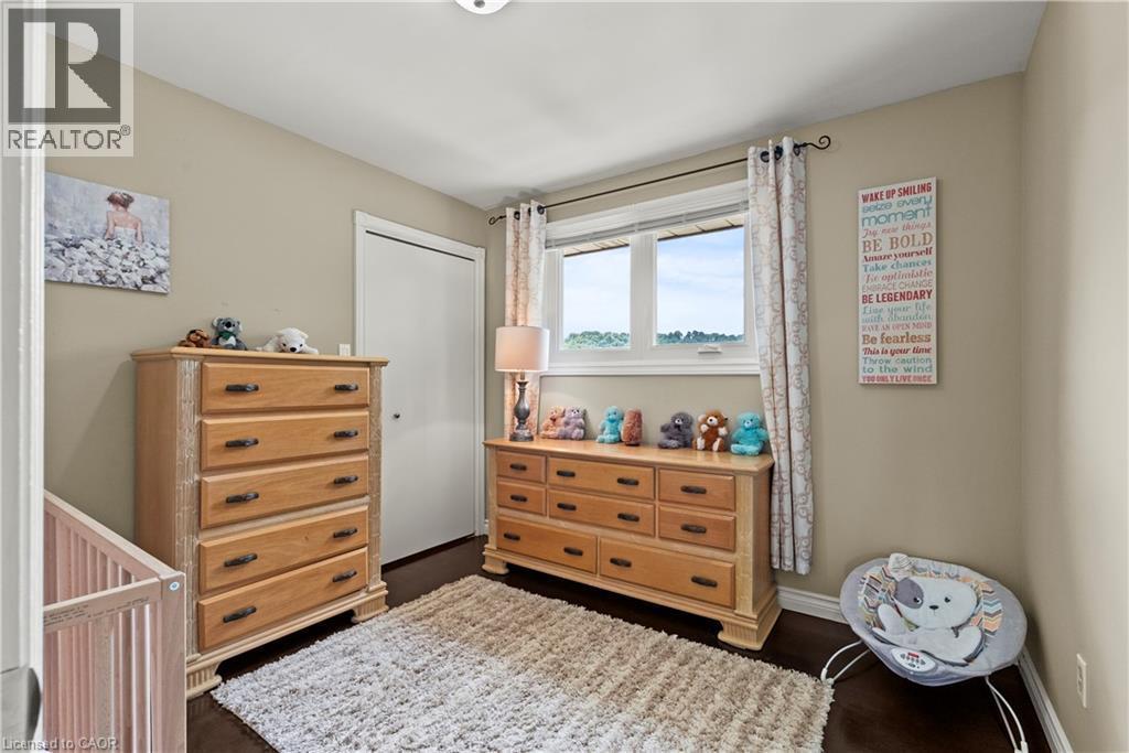 Double-pane window with white trim, dark wood-finish flooring, and a white bi-fold closet door - 87 Monte Drive, Hamilton, ON - Indoor Photo Showing Other Room