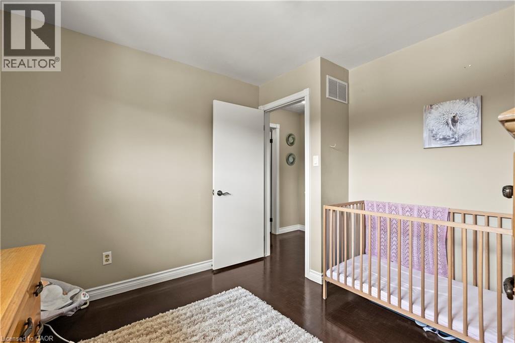 Wood-finish flooring, light neutral wall paint, and white trim throughout - 87 Monte Drive, Hamilton, ON - Indoor Photo Showing Bedroom