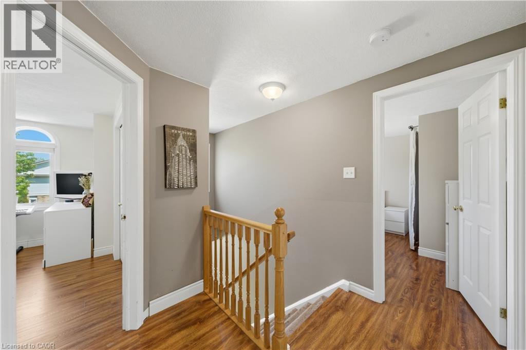 Upper-level hallway featuring wood-finish flooring, a wood banister, and neutral wall tones - 784 Butternut Avenue, Waterloo, ON - Indoor Photo Showing Other Room