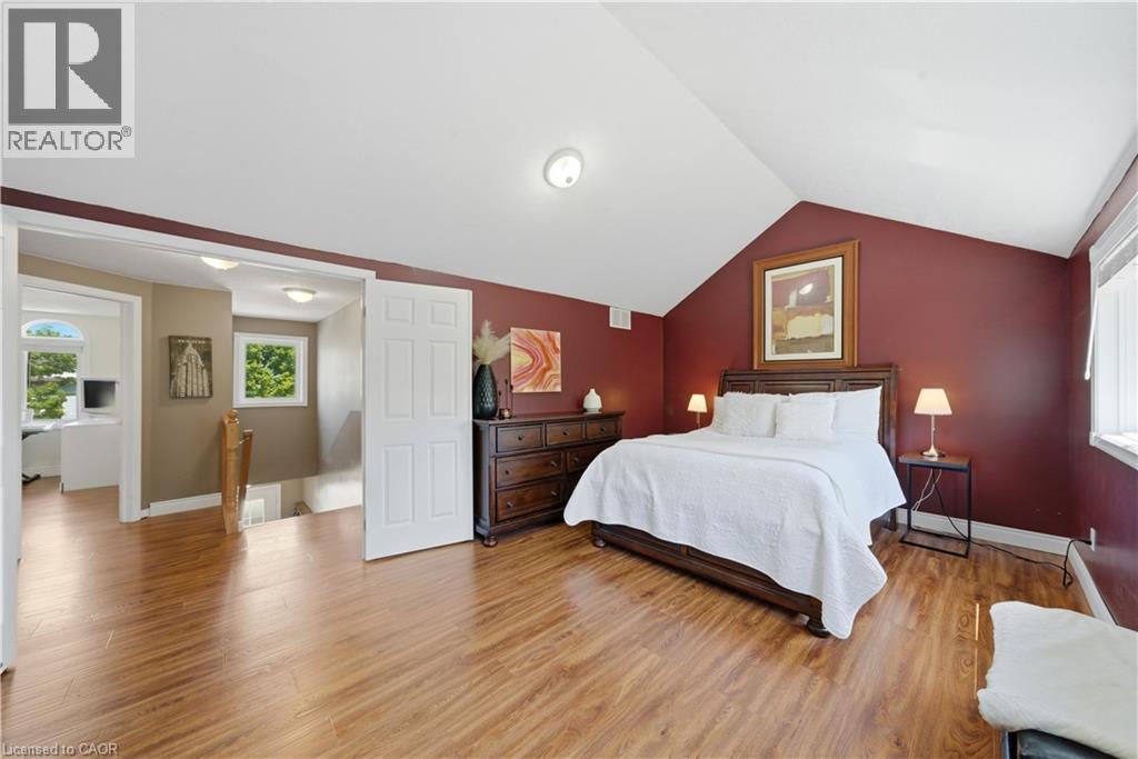 Spacious room featuring wood-finish flooring, a vaulted ceiling, and burgundy painted walls - 784 Butternut Avenue, Waterloo, ON - Indoor Photo Showing Bedroom