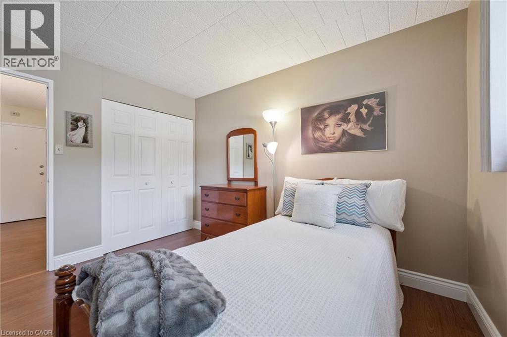 Wood-finish flooring with white trim - 6 Walton Avenue Unit# 107, Kitchener, ON - Indoor Photo Showing Bedroom