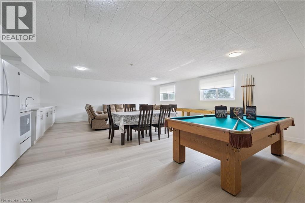 Spacious recreational area featuring light wood-finish flooring, recessed lighting, and multiple windows with roller blinds - 6 Walton Avenue Unit# 107, Kitchener, ON - Indoor Photo Showing Other Room