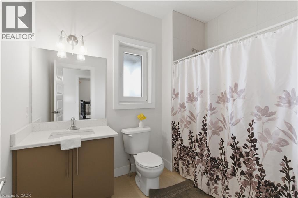 Contemporary bathroom featuring a wood-finish vanity with white quartz countertop, rectangular undermount sink, and chrome fixtures - 2000 Maddex Way, London, ON - Indoor Photo Showing Bathroom