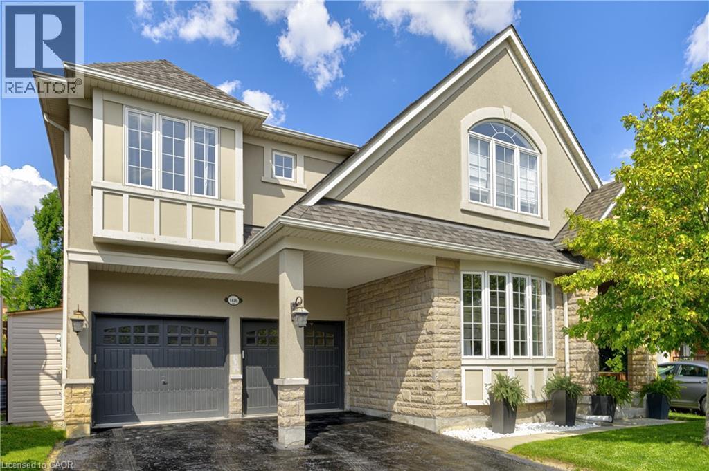 Stucco and stone exterior featuring a covered entryway, a bay window with multiple panes, and an arched window - 1406 Marshall Crescent, Milton, ON - Outdoor With Facade