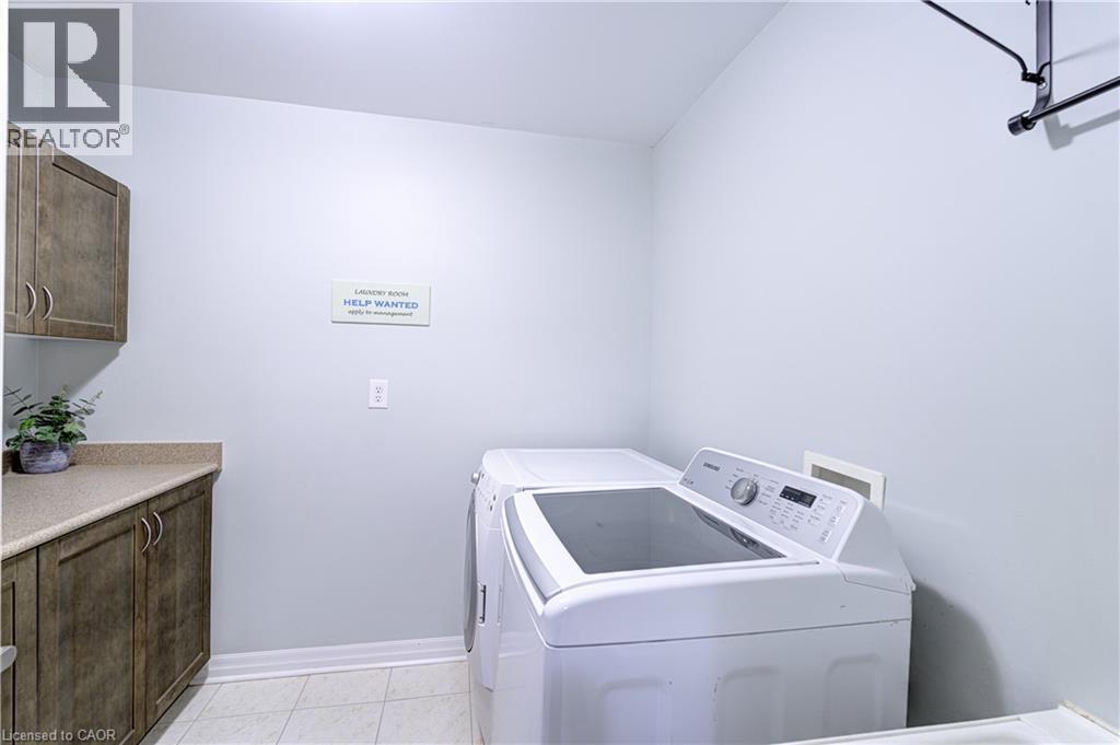 Laundry area with wood-finish cabinetry, light-toned countertop, and tile flooring - 1406 Marshall Crescent, Milton, ON - Indoor Photo Showing Laundry Room