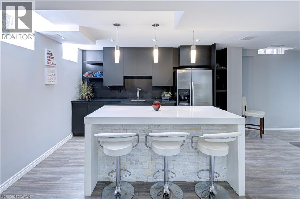 Contemporary kitchen island with a white countertop and stacked stone facade - 1406 Marshall Crescent, Milton, ON - Indoor