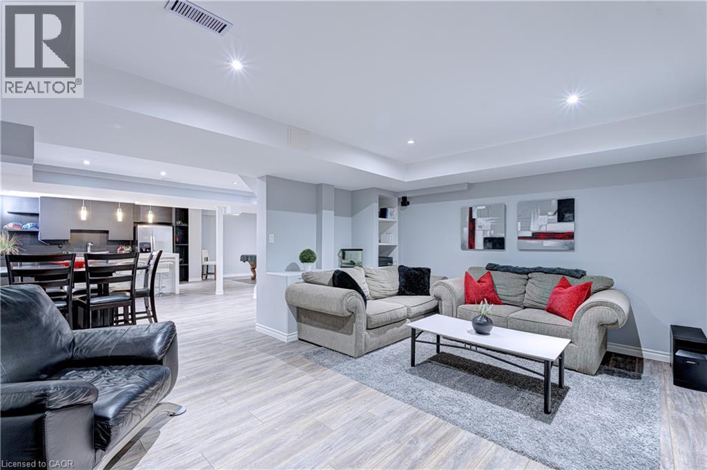 Spacious open-concept interior featuring light wood-finish flooring, recessed lighting, and light gray walls - 1406 Marshall Crescent, Milton, ON - Indoor Photo Showing Living Room