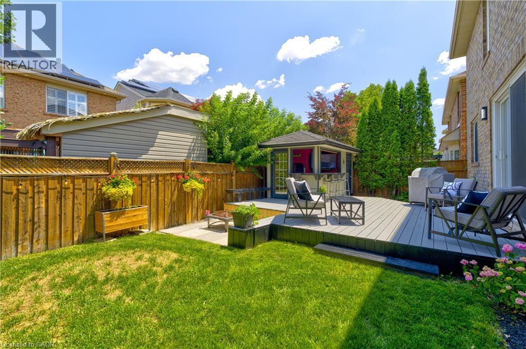 Expansive backyard featuring a multi-level composite deck, a built-in gazebo structure, a lush lawn, and mature perimeter trees - 1406 Marshall Crescent, Milton, ON - Outdoor With Deck Patio Veranda With Exterior