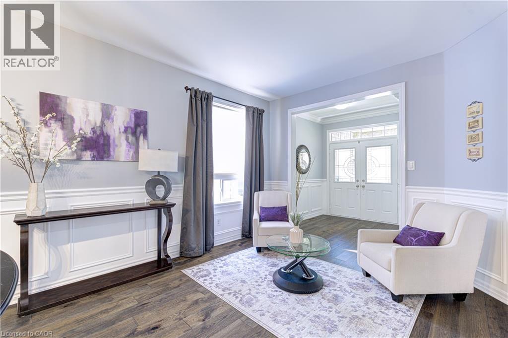 Living area with wood-finish flooring, wainscoting, and an archway leading to the entry - 1406 Marshall Crescent, Milton, ON - Indoor