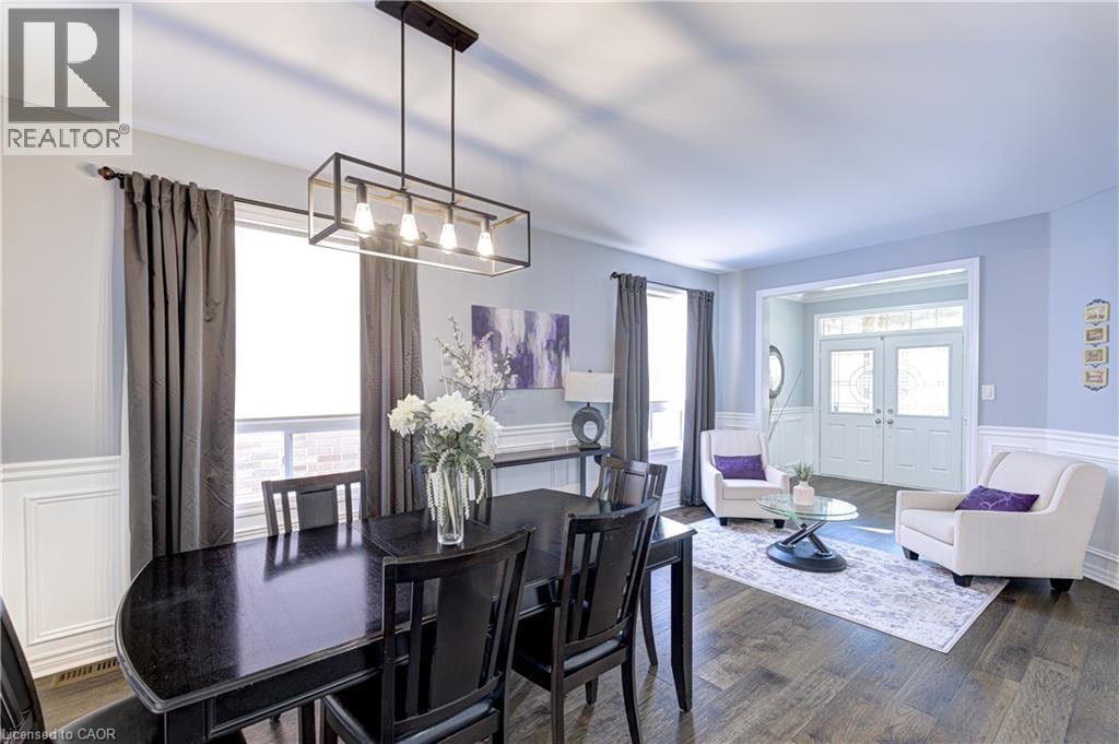 Dining area featuring wood-finish flooring, wainscoting, and an industrial-style linear chandelier - 1406 Marshall Crescent, Milton, ON - Indoor
