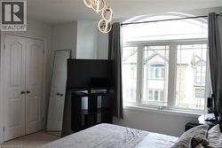 Arched transom window above a multi-pane window unit, contemporary light fixture, and white bi-fold closet doors -