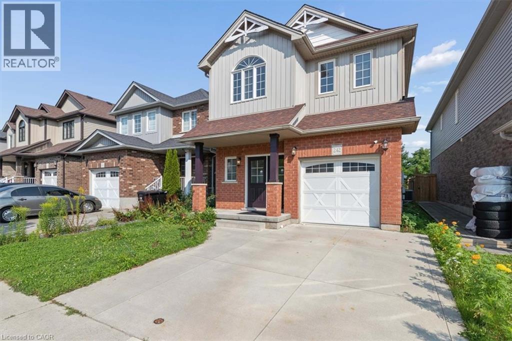 Brick and vertical siding exterior with gabled roof lines, an arched window, and an attached garage with a white panel door - 242 Moorlands Crescent, Kitchener, ON - Outdoor With Facade