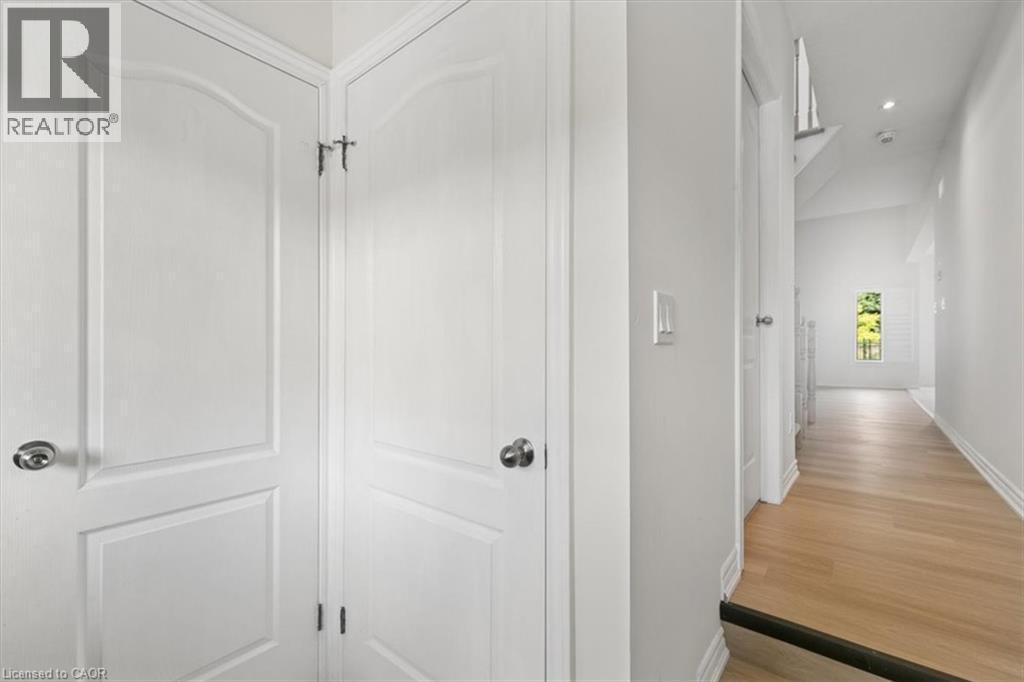 White paneled doors with chrome hardware, light wood-finish flooring, and recessed ceiling lighting - 242 Moorlands Crescent, Kitchener, ON - Indoor Photo Showing Other Room