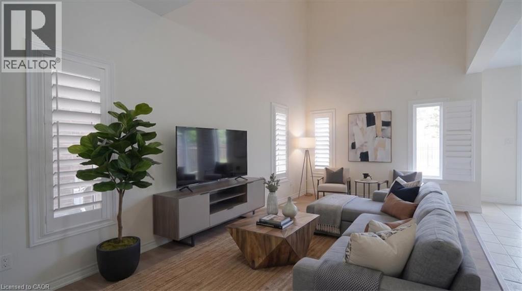 Vaulted ceiling, plantation shutters, wood-finish flooring, and light wall tones - 242 Moorlands Crescent, Kitchener, ON - Indoor Photo Showing Living Room