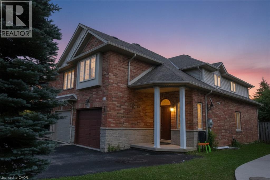 Brick Colonial home featuring a gabled roofline with multiple peaks, illuminated windows, and an attached two-car garage - 509 Southridge Drive, Hamilton, ON - Outdoor