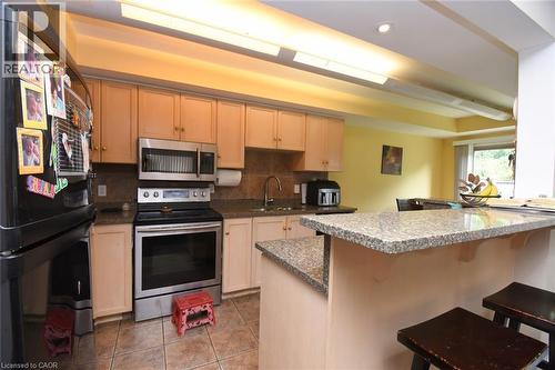 Open-concept kitchen and dining area featuring stainless steel appliances, granite countertops, light wood cabinetry with ample storage, recessed ceiling lighting, and a breakfast bar with seating - 509 Southridge Drive, Hamilton, ON - Indoor Photo Showing Kitchen