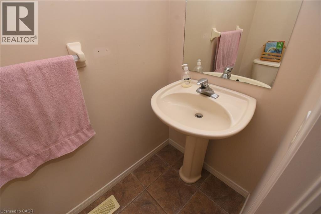 Pedestal sink with chrome-finish faucet, wall-mounted mirror, and tile flooring - 509 Southridge Drive, Hamilton, ON - Indoor Photo Showing Bathroom