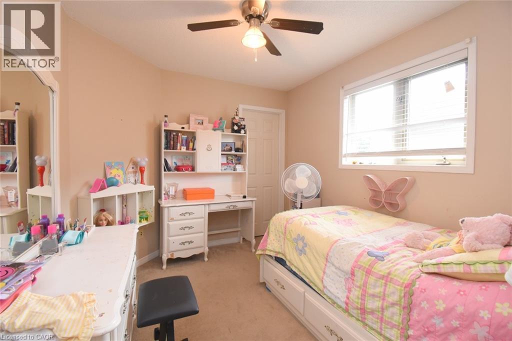 Recessed window with white blinds and trim, light beige walls, ceiling fan with integrated lighting, and a white interior door - 509 Southridge Drive, Hamilton, ON - Indoor Photo Showing Bedroom