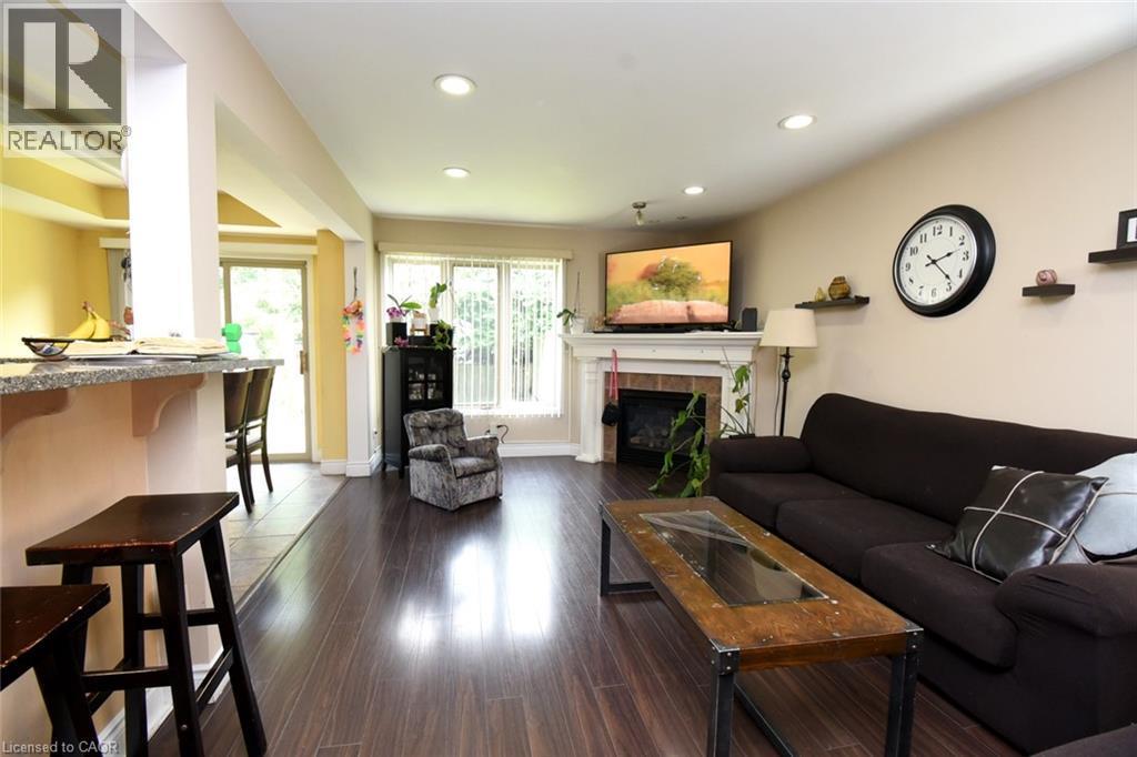 Wood-finish flooring throughout, featuring recessed lighting and a fireplace with a white mantel - 509 Southridge Drive, Hamilton, ON - Indoor Photo Showing Living Room With Fireplace