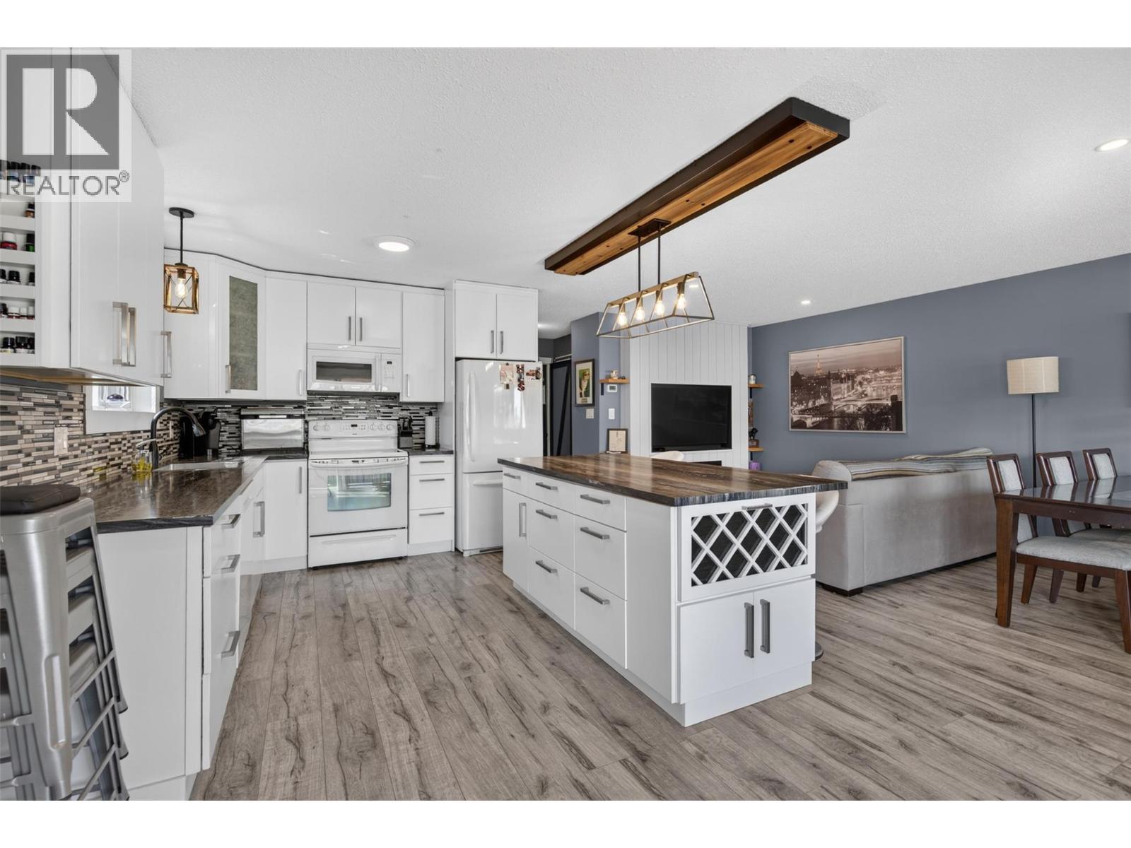 Bright kitchen with a spacious island and plenty of cabinetry. - 3703 Commonage Crescent, Vernon, BC - Indoor Photo Showing Kitchen