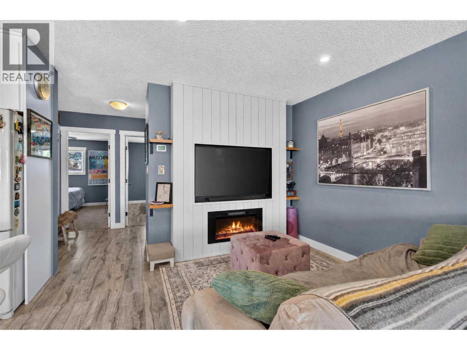 Inviting living room with a cozy fireplace and plenty of natural light. - 3703 Commonage Crescent, Vernon, BC - Indoor Photo Showing Living Room With Fireplace