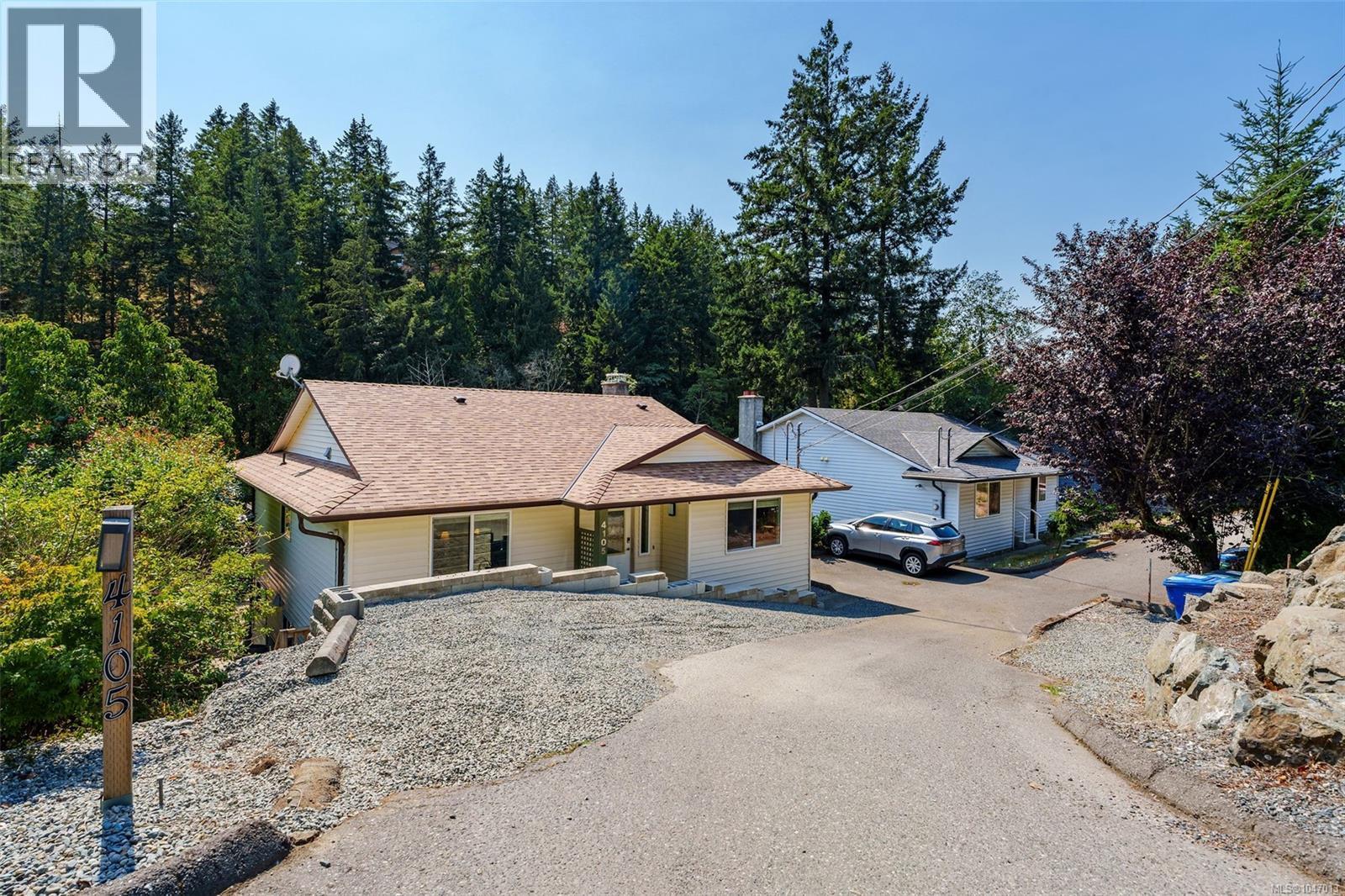 Lots of parking, which is unique to these properties with a pull through driveway, retaining wall, and natural rock landscaping. - 4105 Ross Rd, Nanaimo, BC - Outdoor