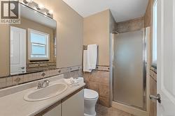 Ensuite. Vanity with integrated sink, chrome faucet, and overhead bar lighting -