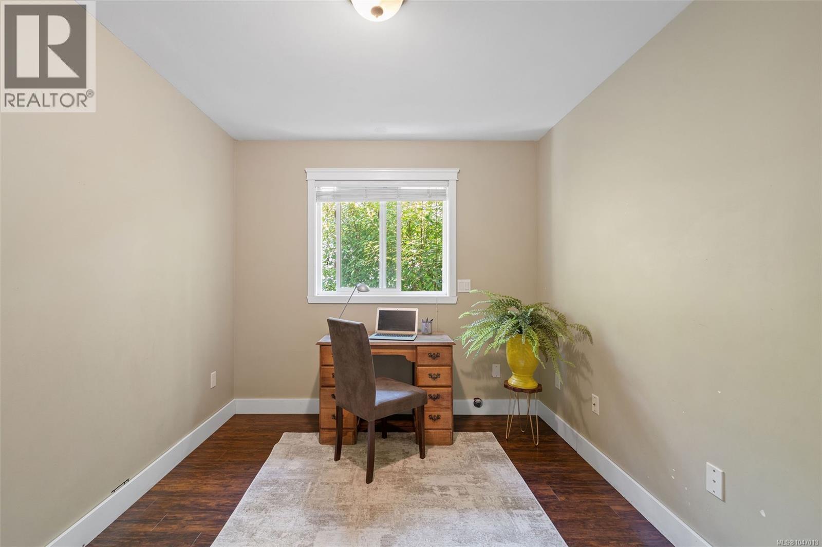 Recessed window with white trim, warm neutral wall paint, wood-finish flooring, and a flush mount ceiling light fixture - 4105 Ross Rd, Nanaimo, BC - Indoor