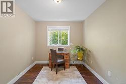 Recessed window with white trim, warm neutral wall paint, wood-finish flooring, and a flush mount ceiling light fixture -