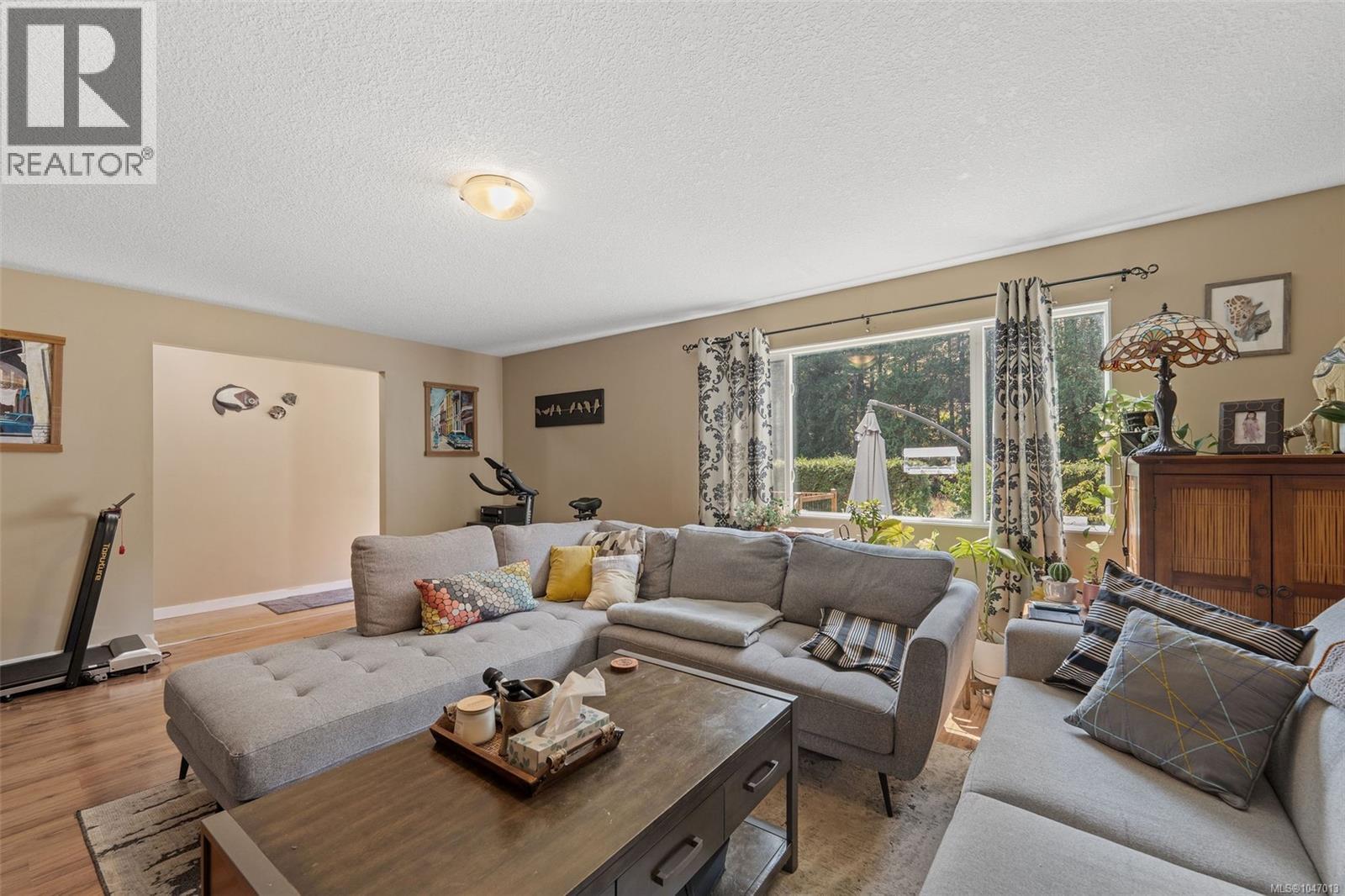 Wood-finish flooring, recessed lighting, and large windows with natural light - 4105 Ross Rd, Nanaimo, BC - Indoor Photo Showing Living Room