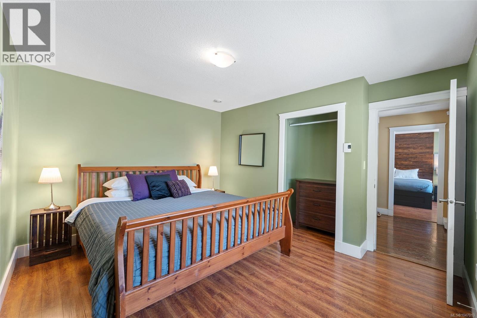 Master bedroom with wood-finish flooring throughout, with a built-in closet and ensuite. - 4105 Ross Rd, Nanaimo, BC - Indoor Photo Showing Bedroom
