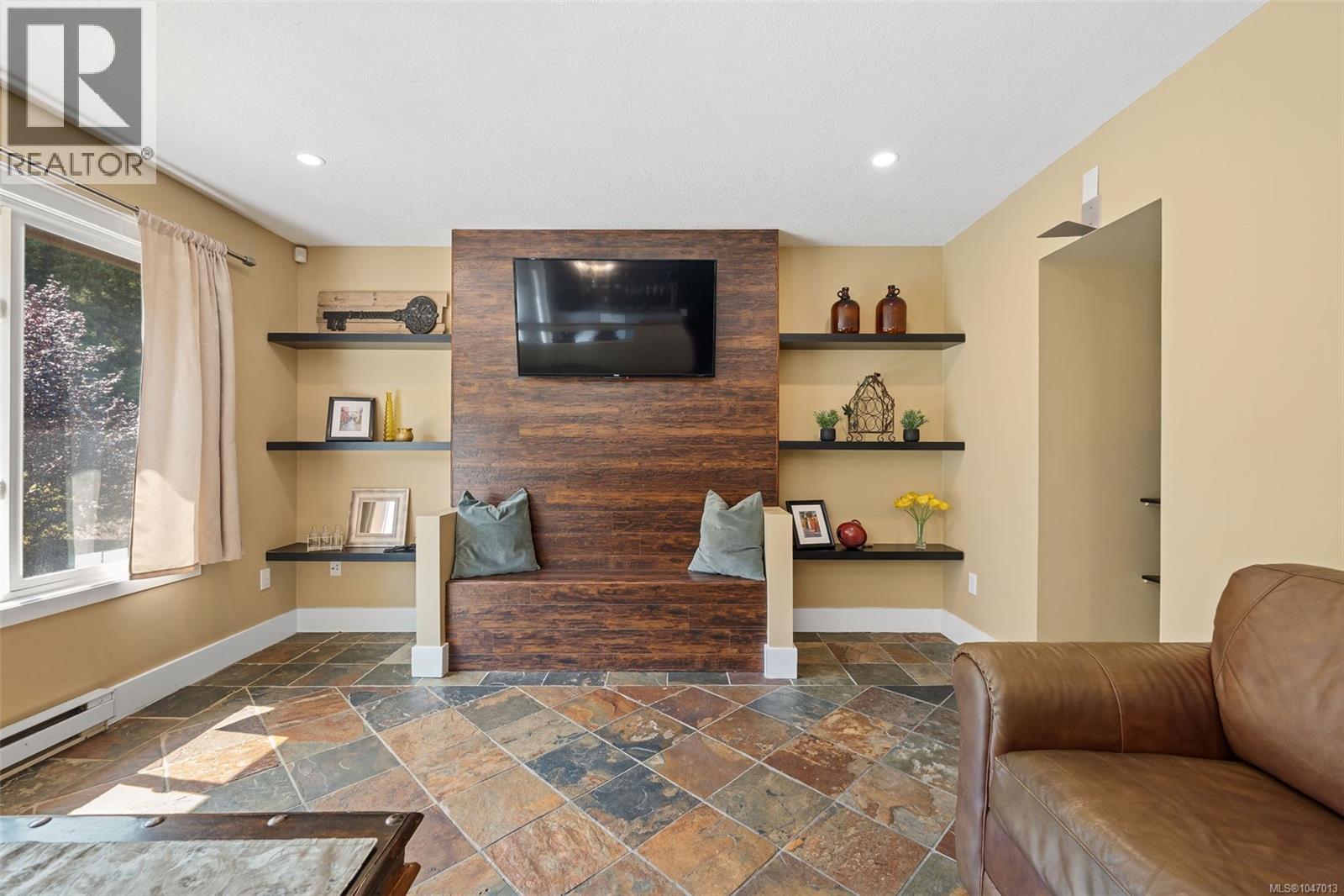 Tile flooring, recessed lighting, built-in shelving, wood-finish accent wall, built-in bench seating and a ductless heat pump/air conditioner. - 4105 Ross Rd, Nanaimo, BC - Indoor