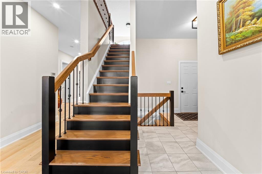 Staircase featuring wood treads, black risers, and wrought iron balusters - 130 Pondcliffe Drive, Kitchener, ON - Indoor Photo Showing Other Room