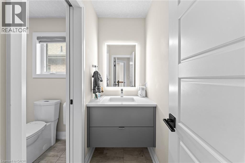 Modern powder room featuring a floating gray vanity with a white countertop and rectangular sink - 130 Pondcliffe Drive, Kitchener, ON - Indoor Photo Showing Bathroom